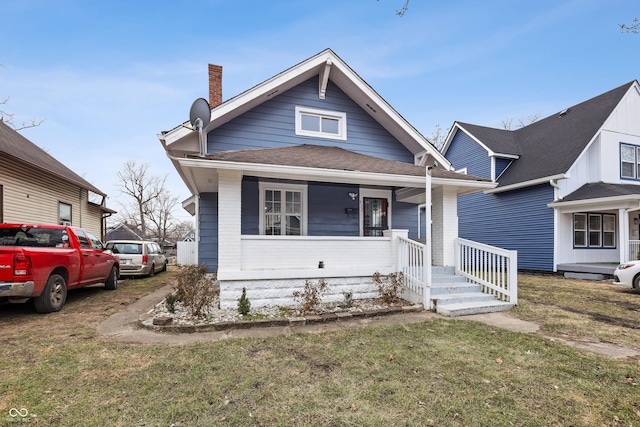 bungalow-style house featuring a porch and a front yard