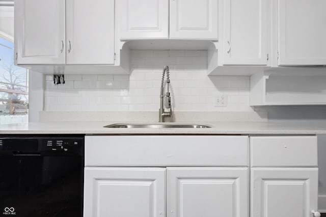 kitchen featuring white cabinetry, black dishwasher, sink, and backsplash