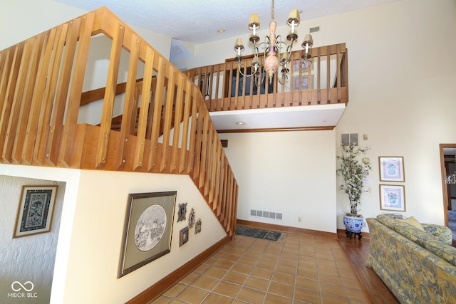 interior space featuring stairs, baseboards, visible vents, and a notable chandelier