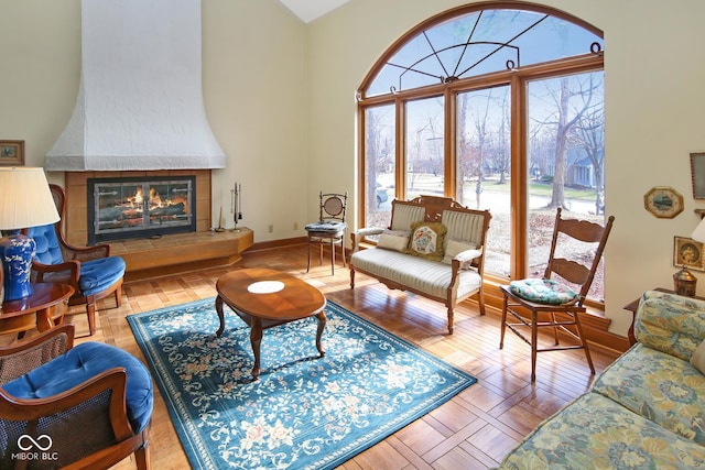 living room featuring a fireplace, baseboards, and wood finished floors