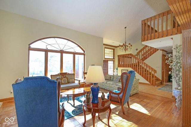 living area with baseboards, parquet floors, a high ceiling, stairs, and a chandelier