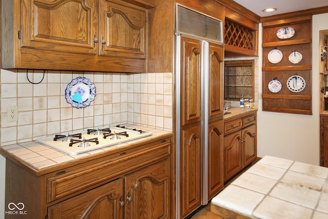 kitchen featuring white gas stovetop, brown cabinets, tile counters, decorative backsplash, and open shelves