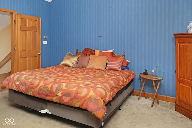 bedroom featuring wallpapered walls, baseboards, and light colored carpet