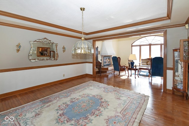 dining area with baseboards, a tray ceiling, hardwood / wood-style floors, and crown molding