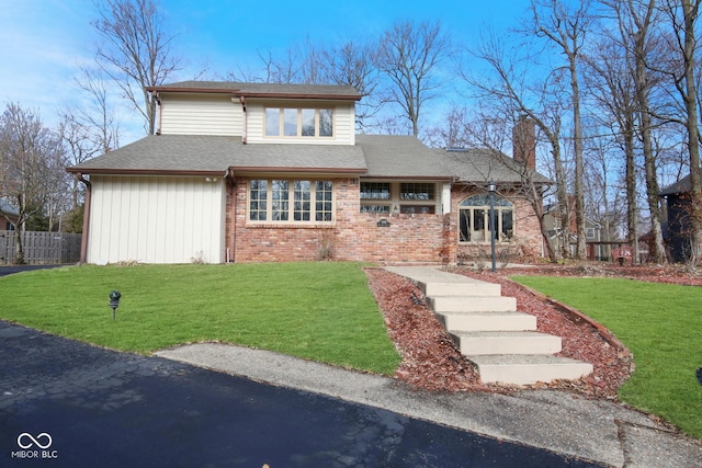 view of front of home featuring a front lawn, a chimney, a shingled roof, and brick siding