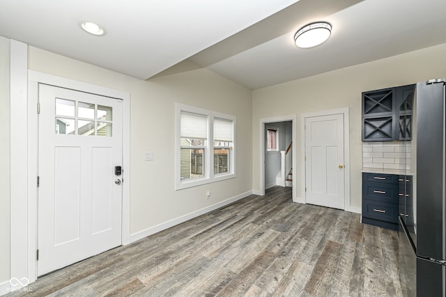 foyer entrance with hardwood / wood-style flooring and vaulted ceiling