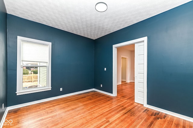 unfurnished room featuring hardwood / wood-style floors and a textured ceiling