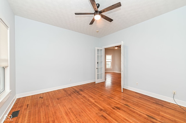 unfurnished room with hardwood / wood-style floors, french doors, and ceiling fan