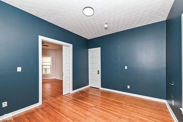 spare room with wood-type flooring and a textured ceiling