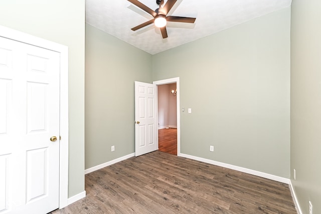 empty room featuring dark wood-type flooring and ceiling fan