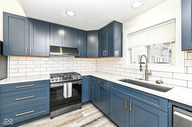 kitchen featuring sink, light hardwood / wood-style flooring, stainless steel gas stove, backsplash, and blue cabinets