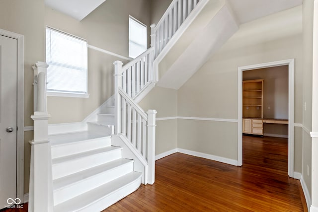 stairs featuring wood finished floors and baseboards