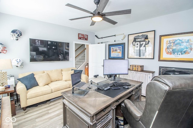 home office with ceiling fan and light hardwood / wood-style floors