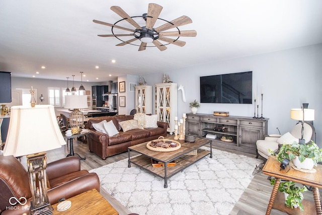 living room featuring light hardwood / wood-style floors and ceiling fan