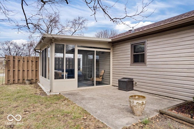 back of property featuring a sunroom, a patio area, and fence