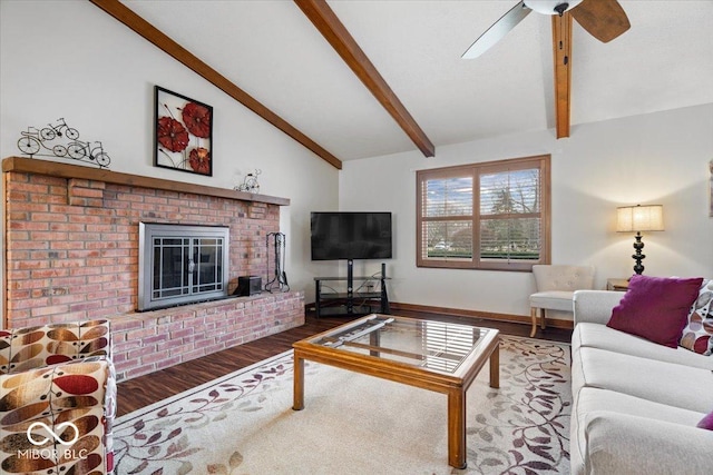 living area with a fireplace, vaulted ceiling with beams, ceiling fan, wood finished floors, and baseboards