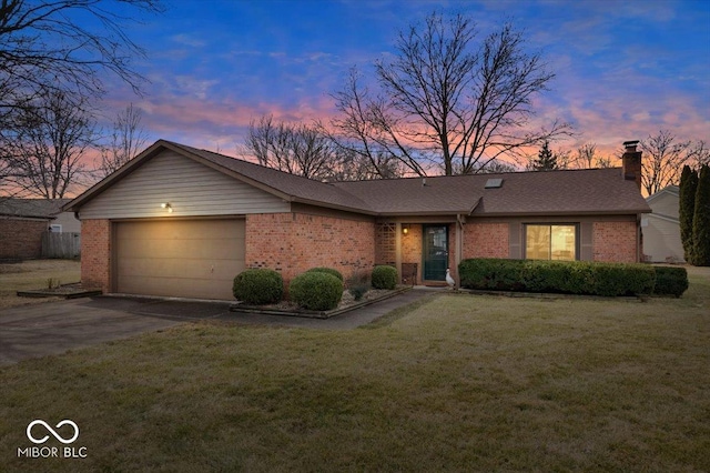 view of front of property featuring a garage, concrete driveway, brick siding, and a front lawn