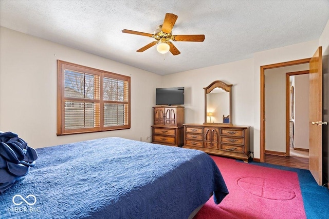 bedroom with a textured ceiling, ceiling fan, and baseboards