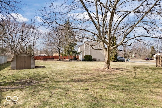 view of yard featuring a storage shed, fence, and an outdoor structure