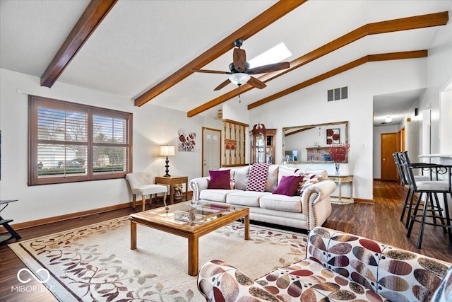 living area featuring a skylight, visible vents, ceiling fan, wood finished floors, and beamed ceiling