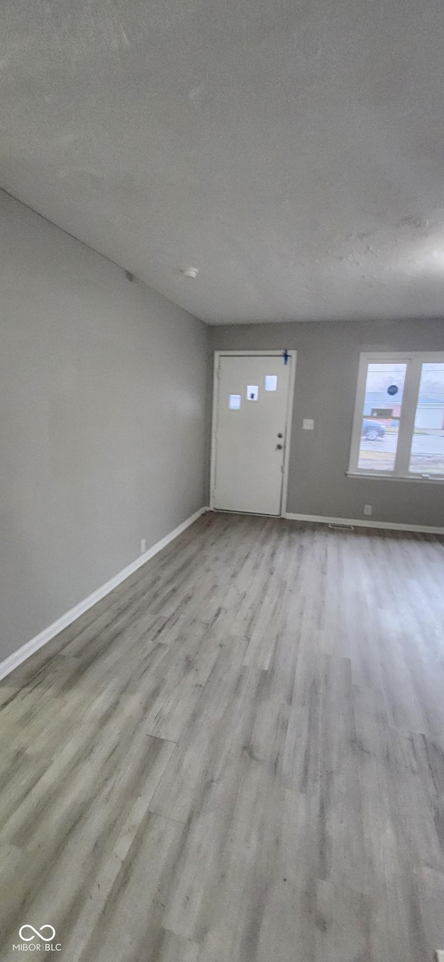 interior space featuring light hardwood / wood-style flooring and a textured ceiling