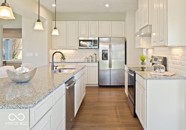 kitchen with sink, white cabinetry, decorative light fixtures, stainless steel appliances, and light stone countertops