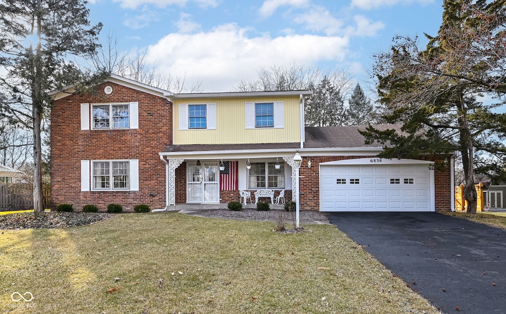 front facade featuring a porch, a garage, and a front yard