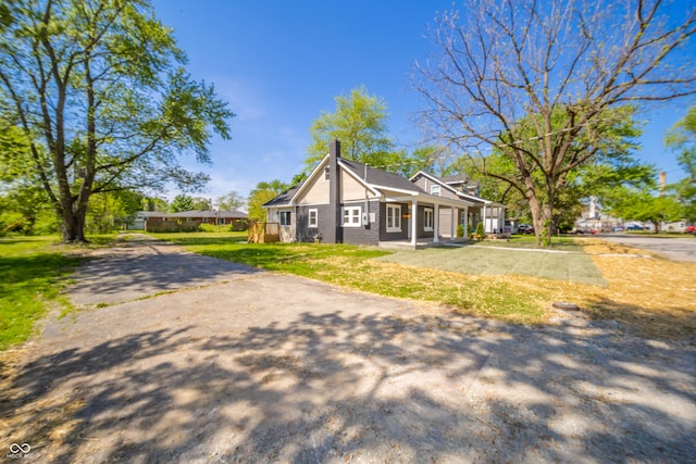 227 W 7th St, Lapel, IN 46051 - view of front of house with a chimney, a front yard, and covered porch