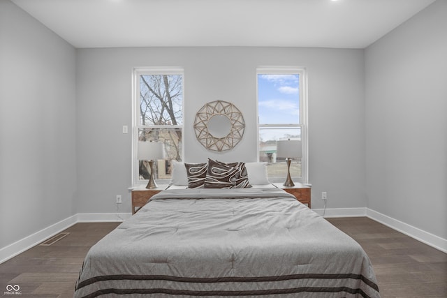 bedroom featuring multiple windows and dark hardwood / wood-style floors