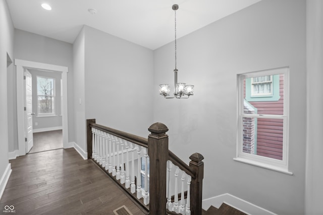 hall with dark hardwood / wood-style flooring and a notable chandelier