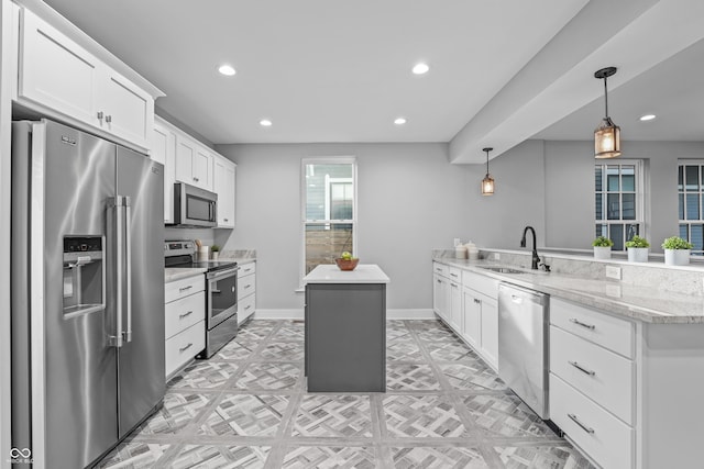 kitchen featuring appliances with stainless steel finishes, sink, white cabinets, hanging light fixtures, and kitchen peninsula