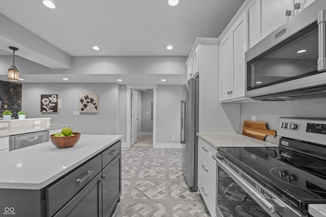 kitchen with white cabinetry, appliances with stainless steel finishes, light stone counters, and decorative light fixtures