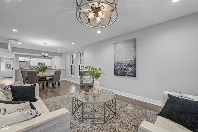 living room with hardwood / wood-style floors and a notable chandelier