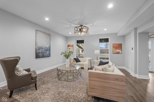 living area with dark wood-type flooring and a notable chandelier