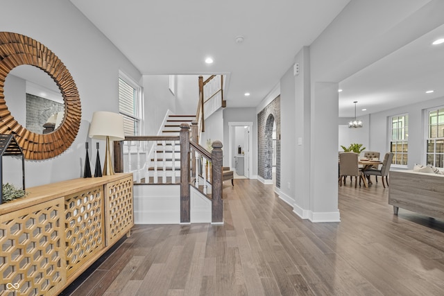 entryway with wood-type flooring and a notable chandelier