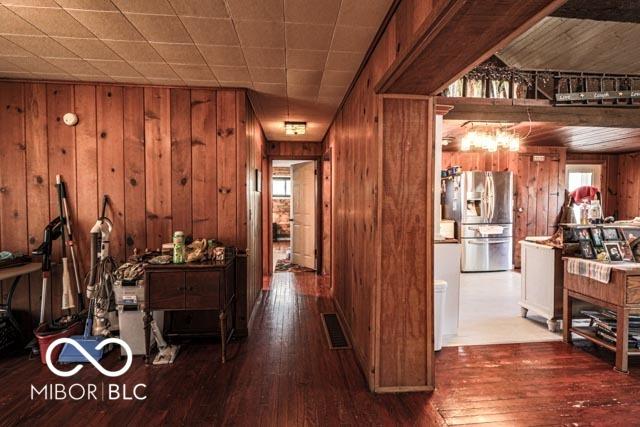 hallway with dark hardwood / wood-style flooring and wood walls