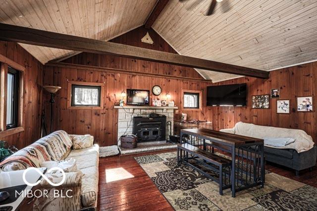 living room with wood-type flooring, vaulted ceiling with beams, wooden ceiling, and wooden walls