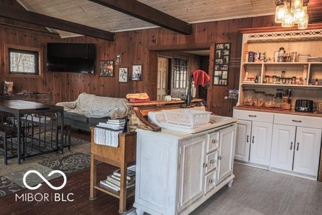 living room featuring dark wood-type flooring, wood ceiling, wooden walls, and beamed ceiling