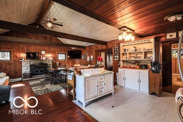 kitchen with a center island, dark hardwood / wood-style floors, white cabinets, and wood walls