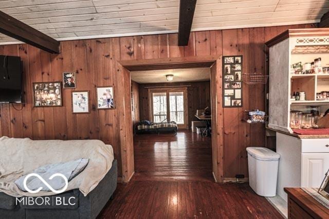 bedroom with dark hardwood / wood-style floors, wood ceiling, beam ceiling, and wood walls