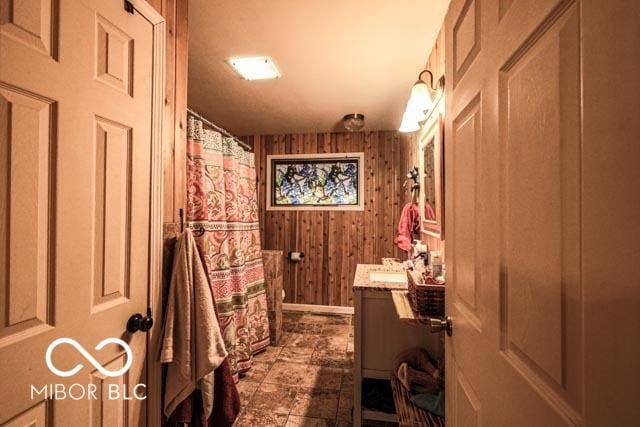 bathroom with vanity and wooden walls