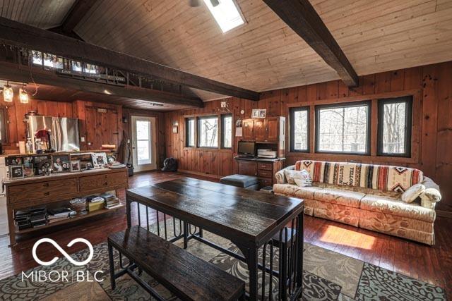 interior space featuring wood ceiling, wooden walls, dark hardwood / wood-style flooring, and lofted ceiling with skylight