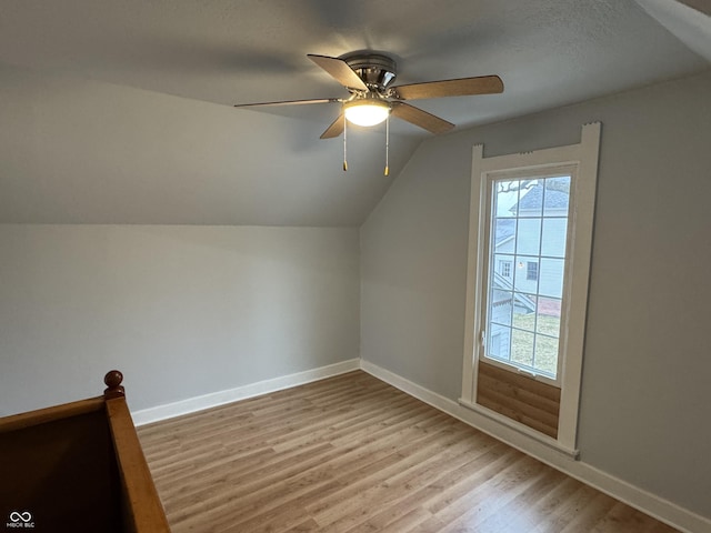 additional living space with ceiling fan, lofted ceiling, and light wood-type flooring