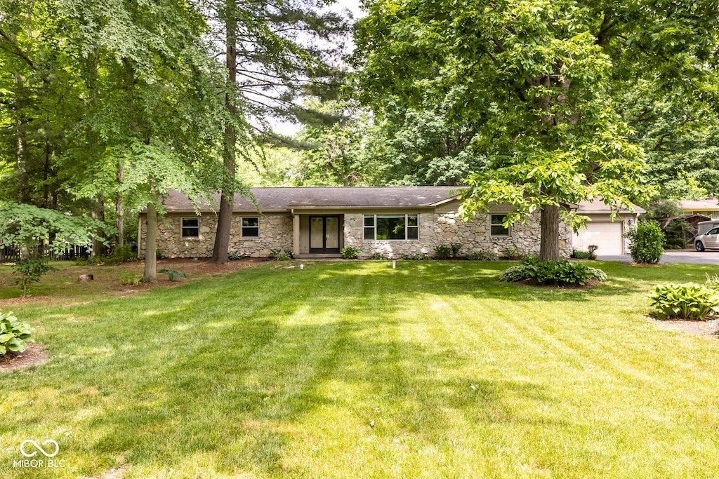 single story home with a garage and a front lawn