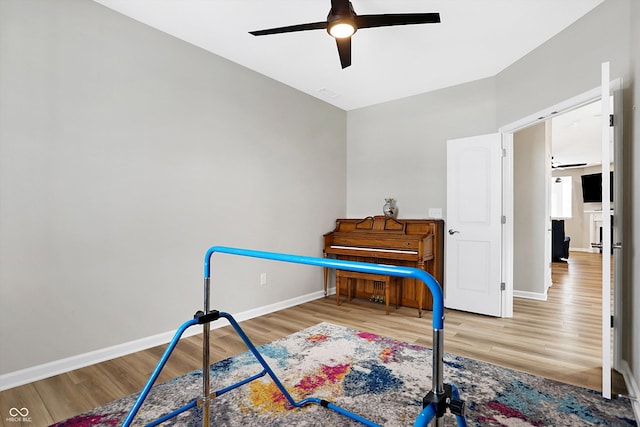 recreation room with baseboards, ceiling fan, and wood finished floors