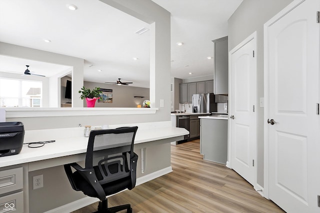 home office with recessed lighting, ceiling fan, a sink, and light wood-type flooring