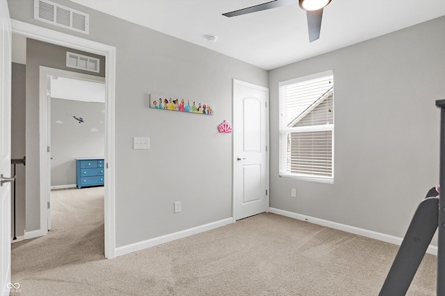 unfurnished bedroom with baseboards, ceiling fan, light carpet, and visible vents