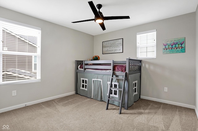 carpeted bedroom with a ceiling fan and baseboards