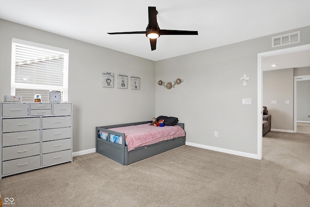 bedroom featuring visible vents, baseboards, ceiling fan, and light carpet