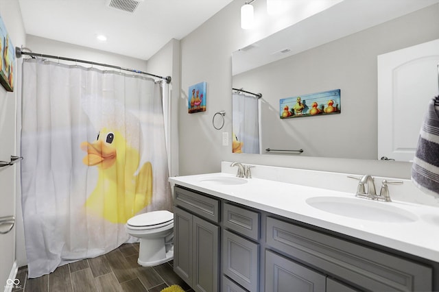 full bathroom featuring visible vents, a sink, wood finished floors, and double vanity